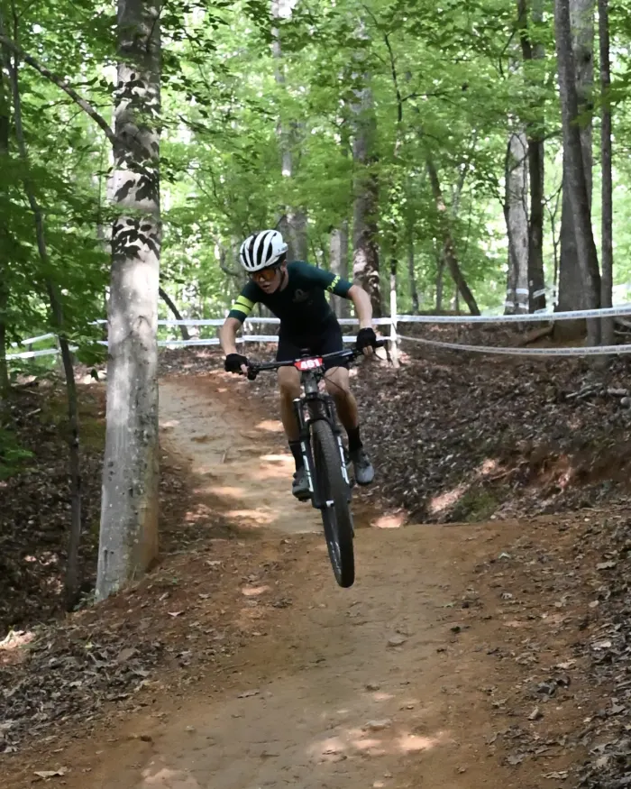 Rider lifting the front wheel on a dirt trail
